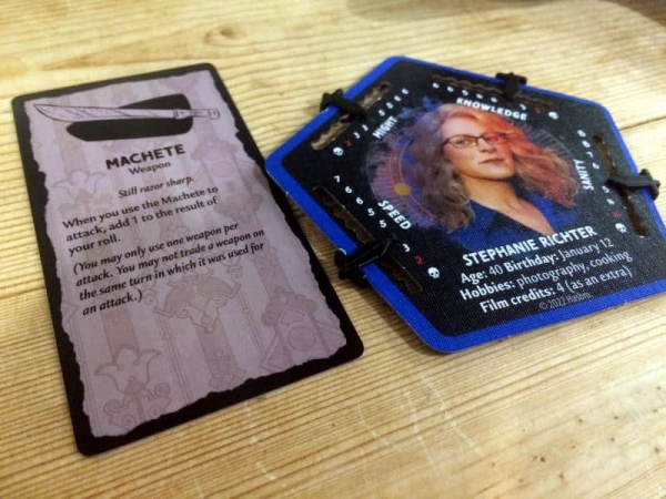 One of the characters and an item card from Betrayal at House on the Hill.